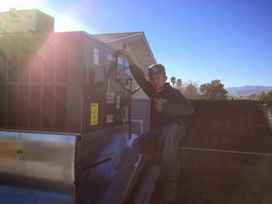 HVAC technician performing Boiler Repair on a rooftop unit in Algoma